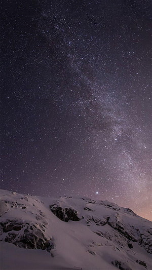 Milky Way Galaxy Rising Over Snow-Covered Mountain Ridge at Night HD phone wallpaper