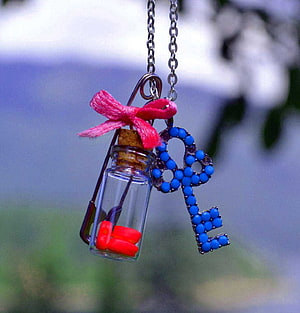 Handcrafted Beaded Key and Tiny Glass Bottle Charm Hanging on a Chain HD phone wallpaper