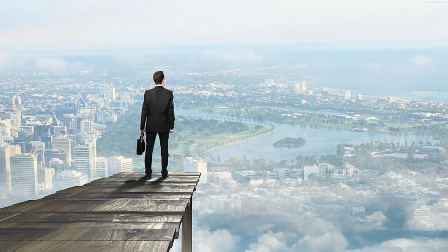 Businessman in a suit standing on a wooden platform overlooking a sprawling city skyline HD wallpaper