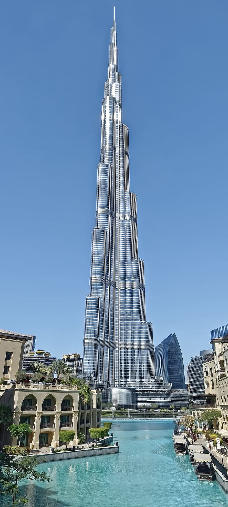 Burj Khalifa Tower Rising Over Dubai Canal With Clear Blue Sky HD phone wallpaper
