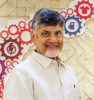 Portrait of N. Chandrababu Naidu in a white shirt against an industrial gear backdrop HD phone wallpaper