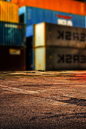 Stacked Shipping Containers at a Port Yard with Warm Golden Hour Lighting HD phone wallpaper