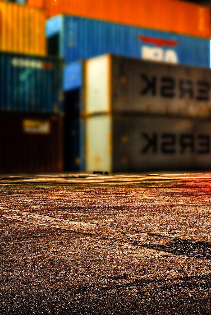 Stacked Shipping Containers at a Port Yard with Warm Golden Hour Lighting HD phone wallpaper
