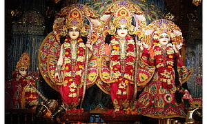 Lord Rama, Sita, and Lakshmana adorned in vibrant floral garlands and ornate temple regalia HD wallpaper