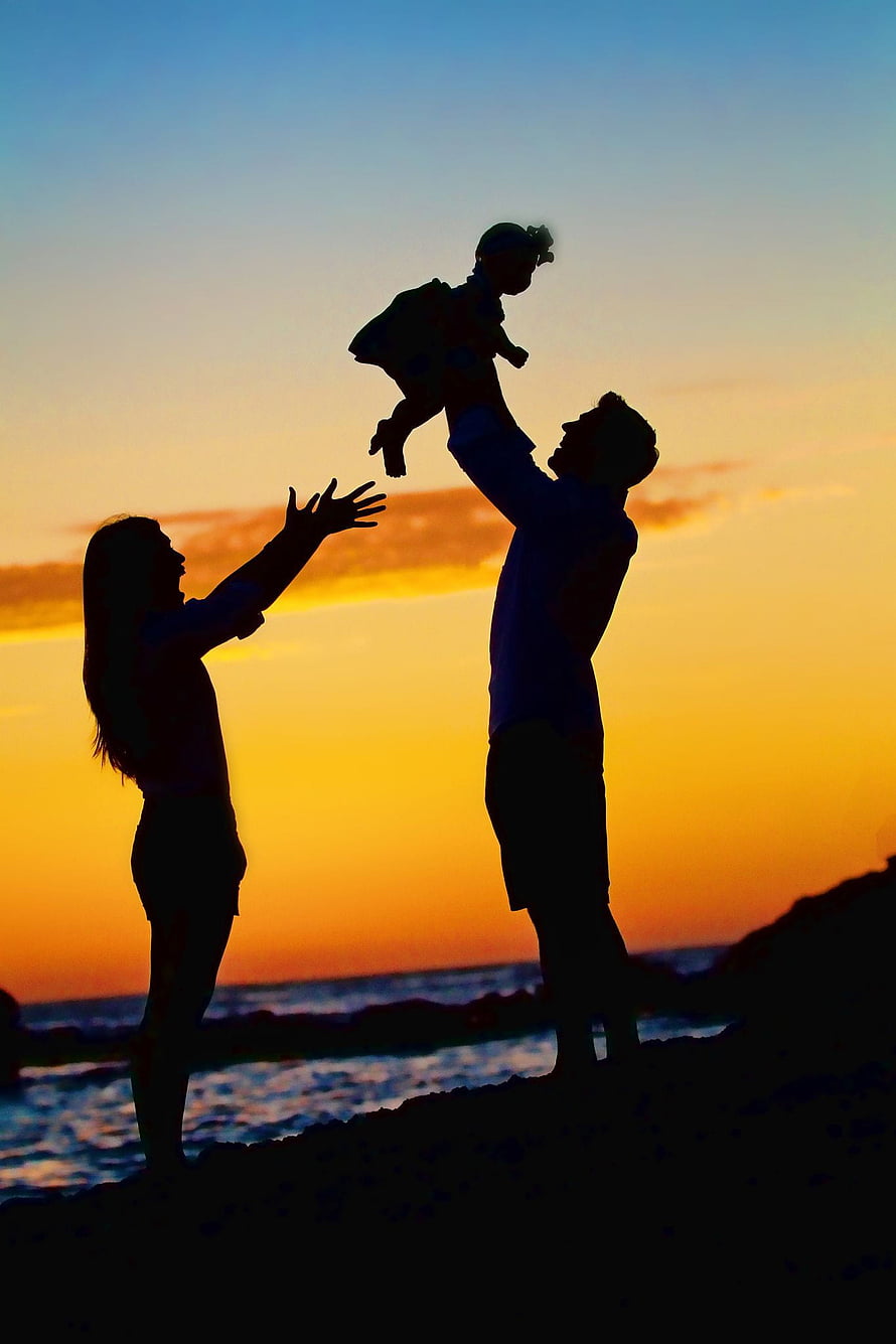 Silhouette of a family playing on the beach at sunset with a baby in the air HD phone wallpaper