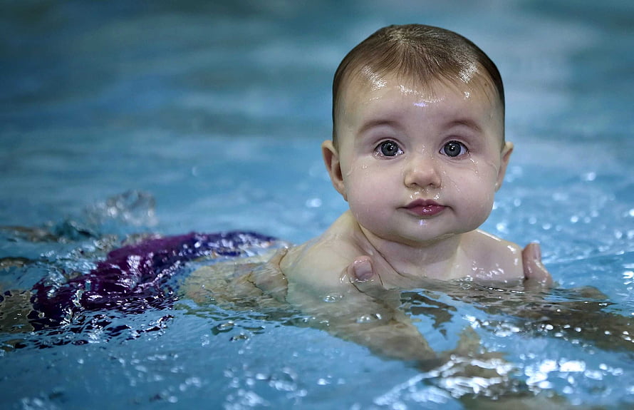 Adorable Baby Boy Swimming in a Blue Pool with Water Droplets on Face HD wallpaper