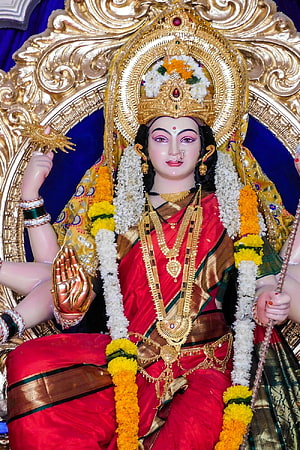 Ornate Durga Maa Murti Adorned in Red Saree with Gold Jewelry and Marigold Garlands HD phone wallpaper
