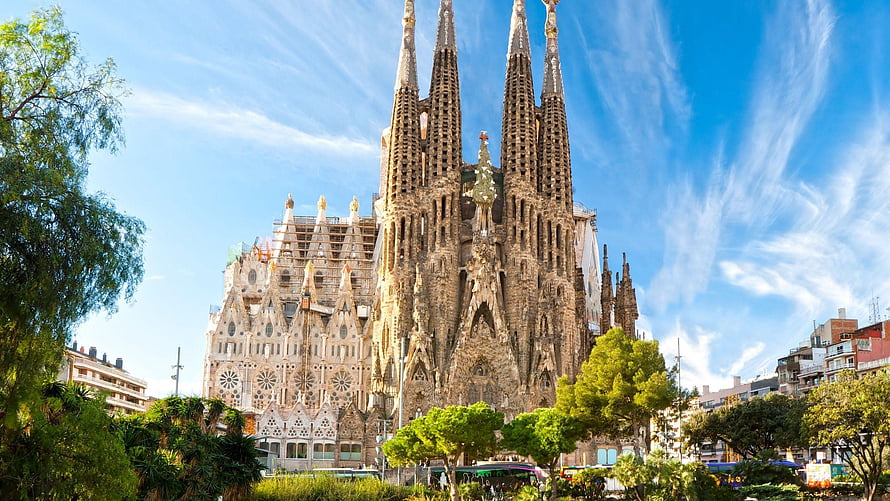 Sagrada Familia Cathedral in Barcelona with towering spires and intricate Gothic facade under a bright blue sky HD wallpaper
