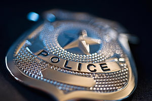 Close-Up of a Shiny Silver Police Badge with Star Emblem and Text HD wallpaper
