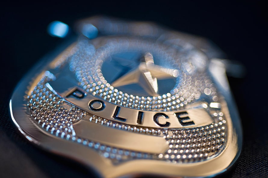 Close-Up of a Shiny Silver Police Badge with Star Emblem and Text HD wallpaper