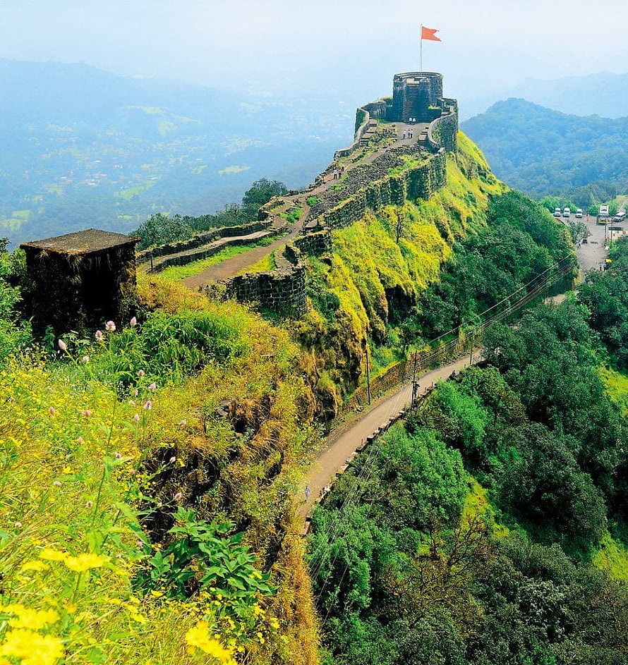Pratapgad Fort on a lush green hilltop in Maharashtra with a red flag and winding stone walls HD phone wallpaper