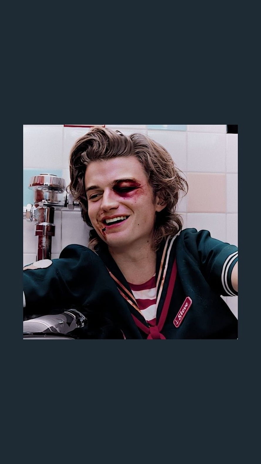 Steve Harrington from Stranger Things with a bruised eye and a grin in a tiled bathroom HD phone wallpaper