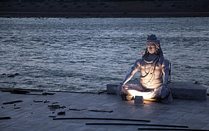 Lord Shiva Statue Meditating by the River at Dusk HD wallpaper