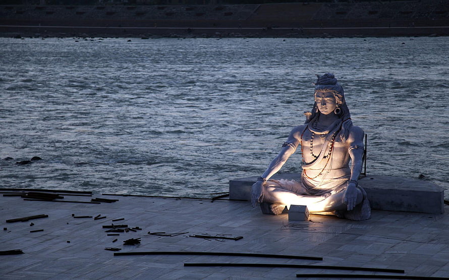 Lord Shiva Statue Meditating by the River at Dusk HD wallpaper