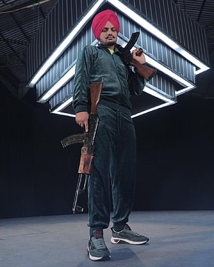 Sidhu Moose Wala in Green Tracksuit and Pink Turban Holding AK-47 Rifles HD phone wallpaper