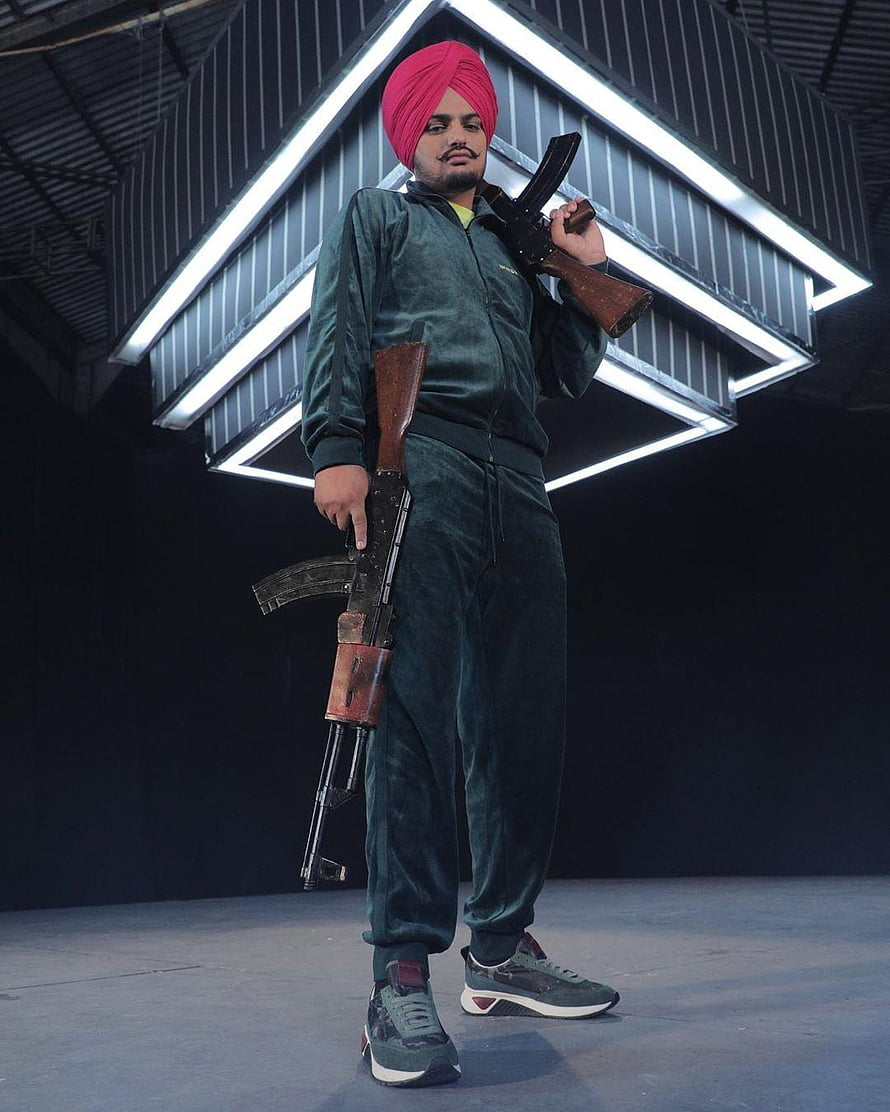 Sidhu Moose Wala in Green Tracksuit and Pink Turban Holding AK-47 Rifles HD phone wallpaper