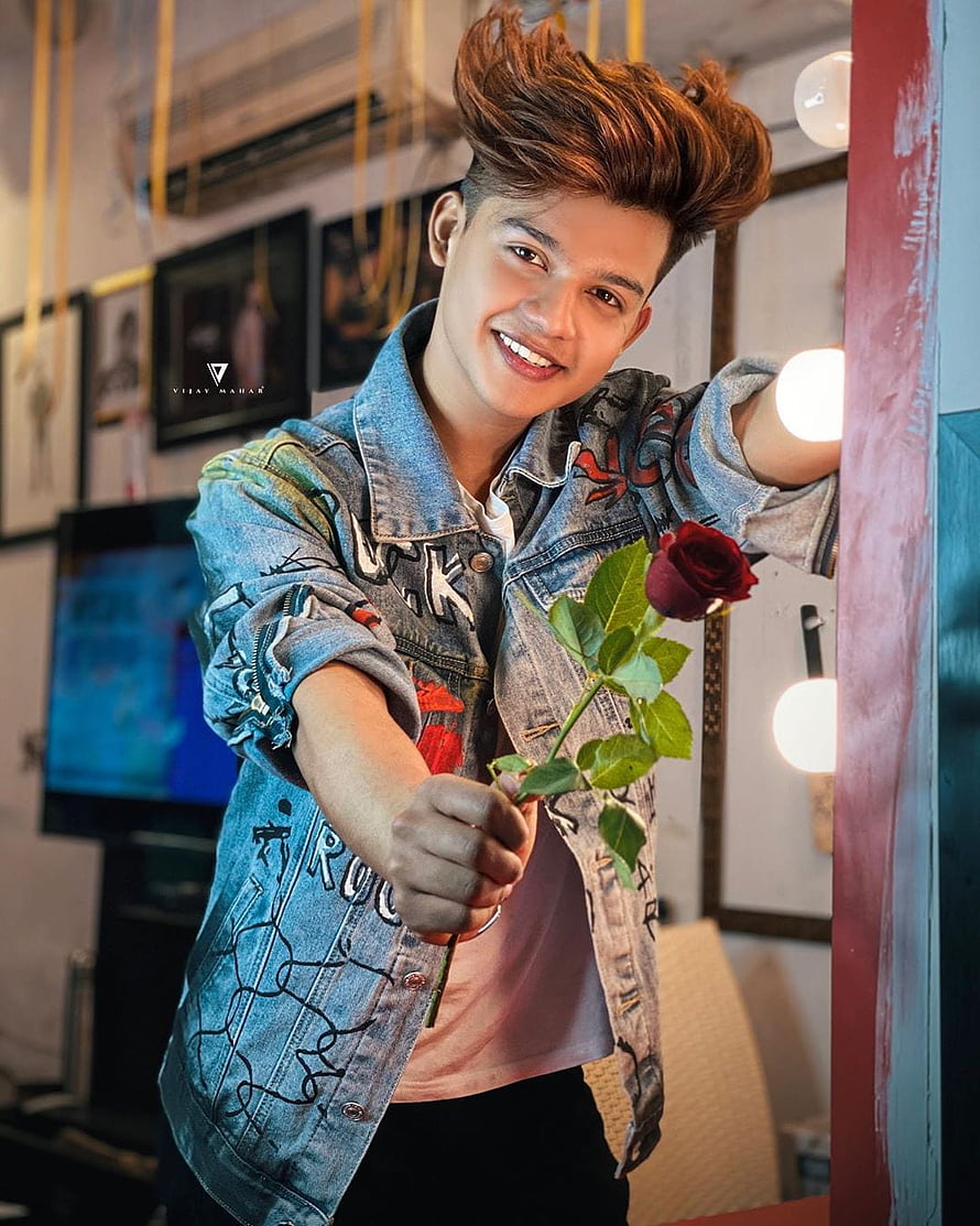 Riyaz Ali in a Painted Denim Jacket Holding a Red Rose in a Studio HD phone wallpaper