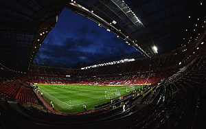Old Trafford Stadium Interior at Night with Manchester United Seating and Pitch HD wallpaper