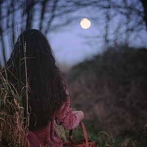Woman with long dark hair sitting in a field at dusk with a full moon in the sky HD phone wallpaper