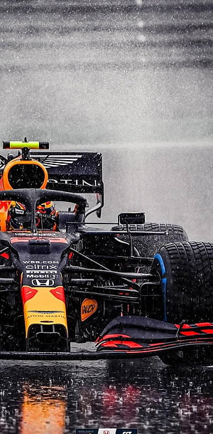 Red Bull Racing Formula 1 car navigating wet track in heavy rain HD phone wallpaper