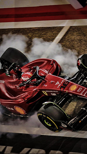Ferrari Formula 1 car drifting through smoke on a race track HD phone wallpaper