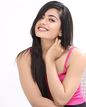 Rashmika Mandanna smiling portrait in a pink tank top with long dark hair HD phone wallpaper