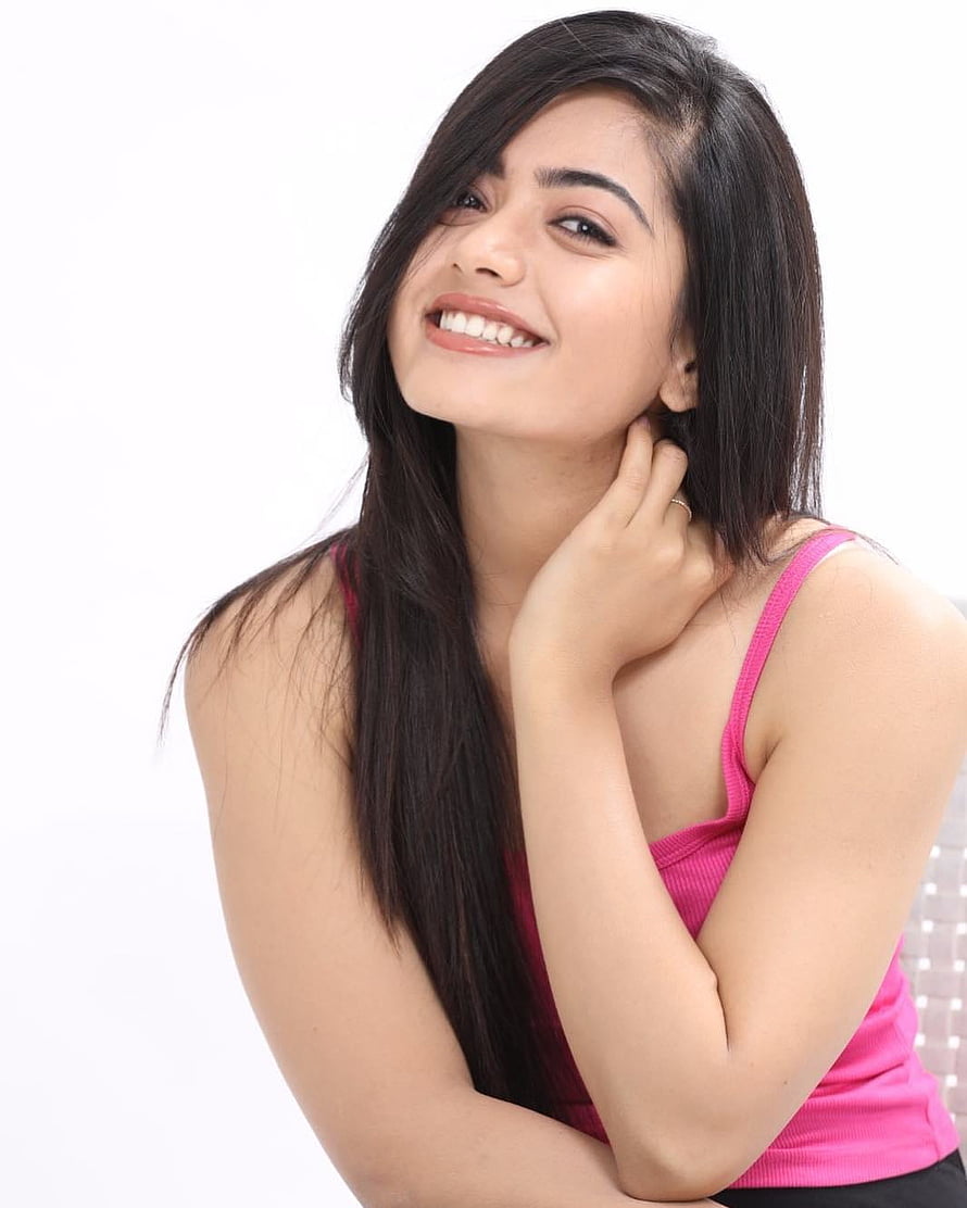 Rashmika Mandanna smiling portrait in a pink tank top with long dark hair HD phone wallpaper