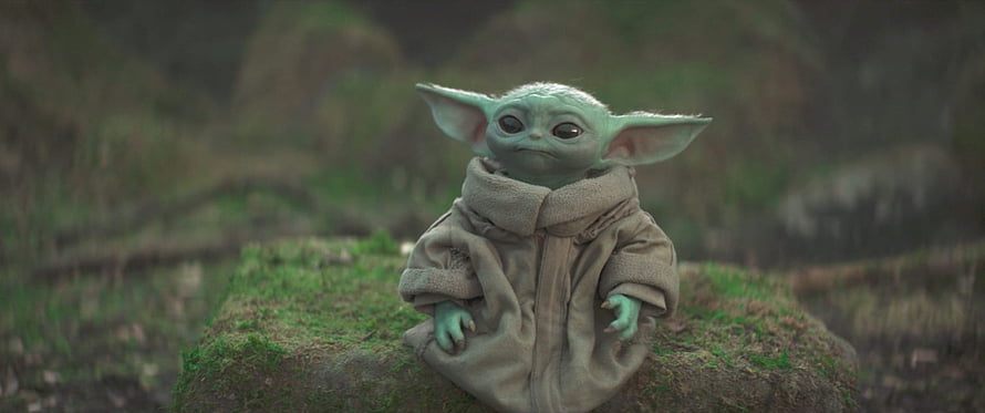 Grogu from The Mandalorian Sitting on a Mossy Stone in a Forest HD wallpaper