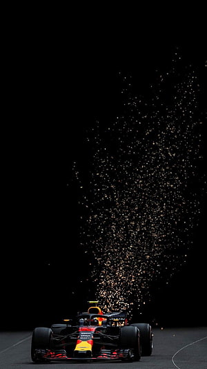 Red Bull Racing Formula 1 car emitting sparks on a dark track at night HD phone wallpaper