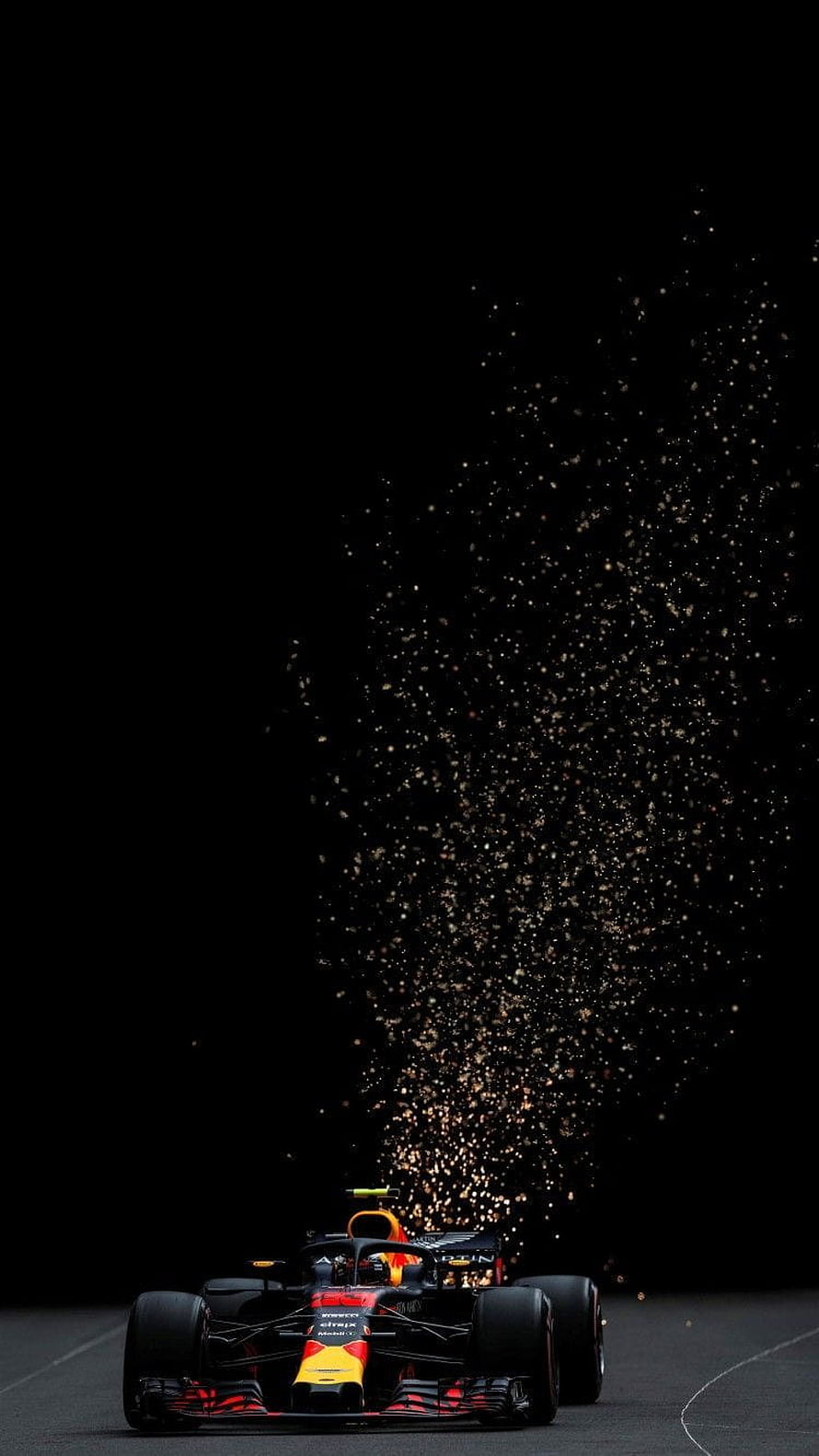 Red Bull Racing Formula 1 car emitting sparks on a dark track at night HD phone wallpaper
