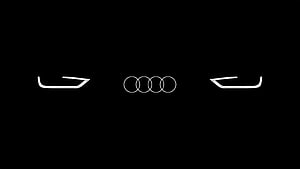 Audi Four Rings Emblem with Sleek Headlight Design on Black Background HD wallpaper