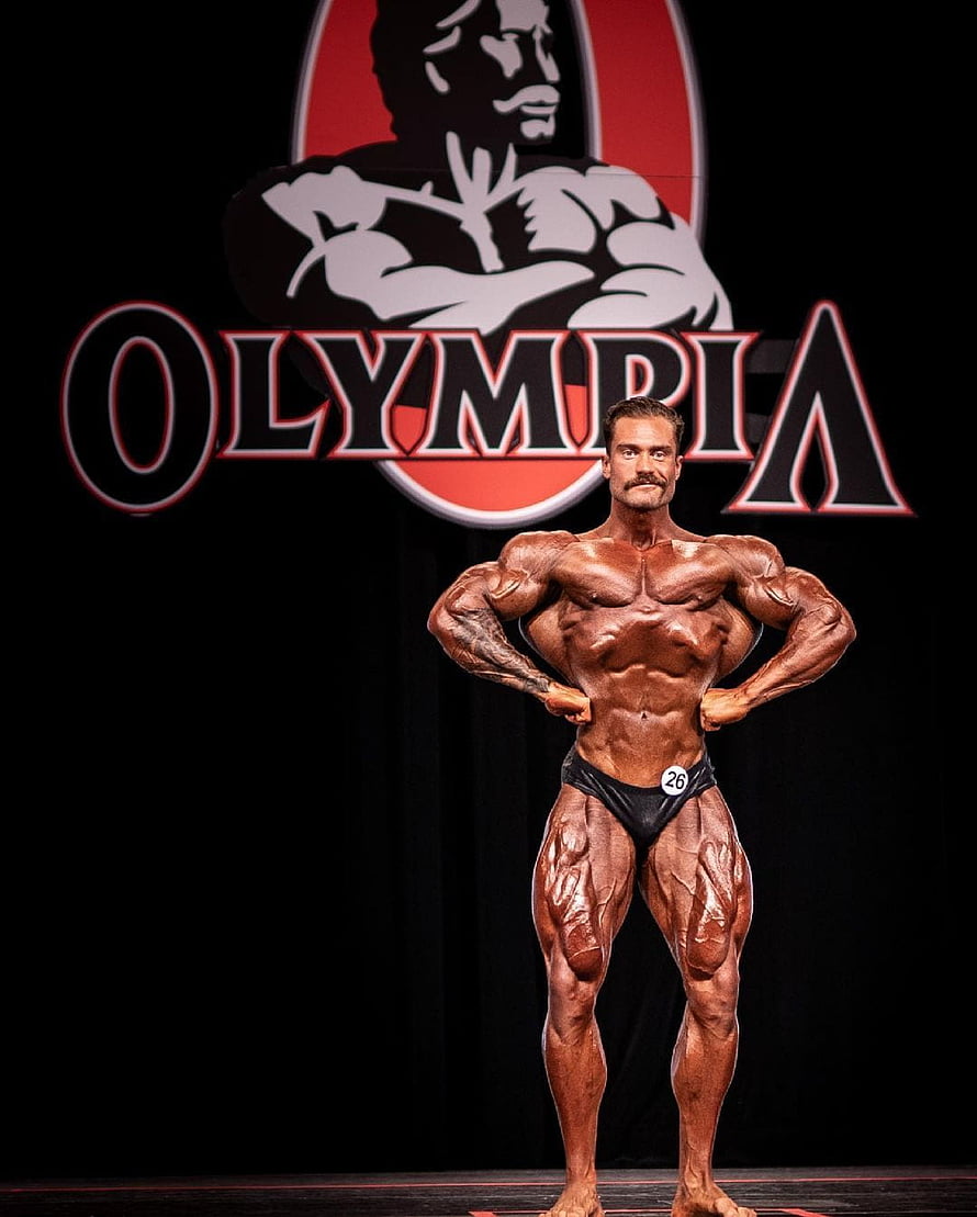 Chris Bumstead Bodybuilder Poses on Stage at the Olympia Competition HD phone wallpaper