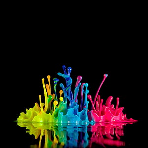 Vibrant multicolored paint splashes erupting on a reflective black surface HD phone wallpaper