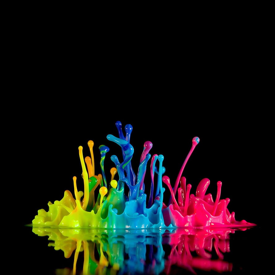 Vibrant multicolored paint splashes erupting on a reflective black surface HD phone wallpaper