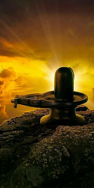 Shivaling on Rocky Outcrop Against Dramatic Golden Sunset Sky HD phone wallpaper