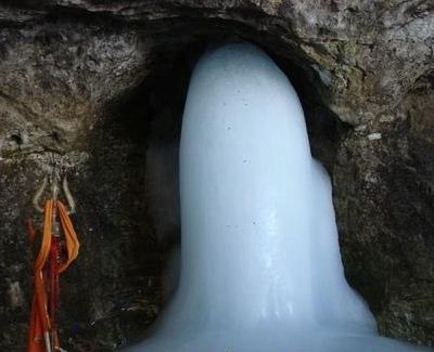 Amarnath Cave Temple Interior with Hanging Ice Stalactite and Sacred Orange Offerings HD wallpaper