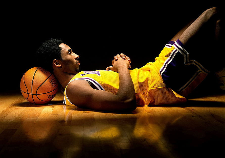 Kobe Bryant in Lakers Jersey Lying on Basketball Court with Ball HD wallpaper
