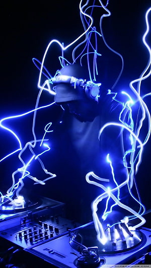 DJ performing at a turntable setup with glowing blue light trails and neon effects HD phone wallpaper