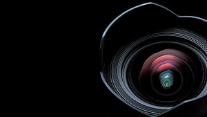 Close-up of a camera lens with colorful reflections on a black background HD wallpaper