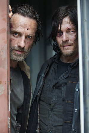 Rick Grimes and Daryl Dixon Peering Through a Rusty Doorway in The Walking Dead HD phone wallpaper