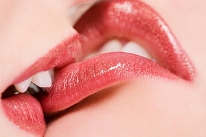 Close-up of glossy red lips and teeth in a sensual intimate portrait HD wallpaper
