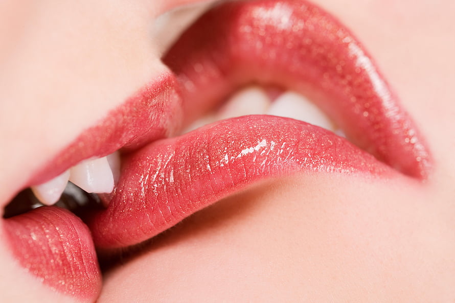 Close-up of glossy red lips and teeth in a sensual intimate portrait HD wallpaper