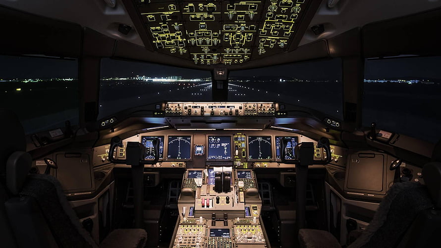 Boeing 777 Cockpit Interior at Night with Illuminated Flight Deck Panels and Runway View HD wallpaper