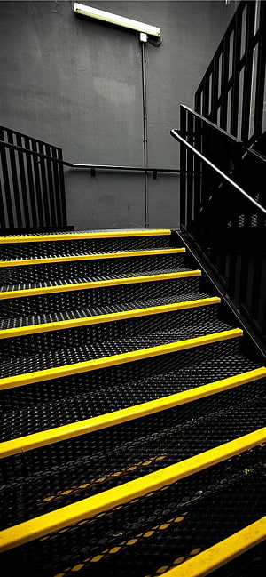 Industrial metal staircase with yellow safety edges and black railings HD phone wallpaper
