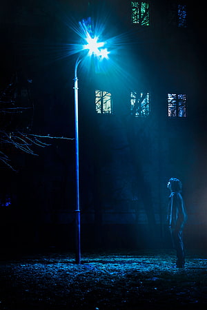 Solitary Figure Standing Under a Glowing Streetlight in a Dark Urban Setting HD phone wallpaper