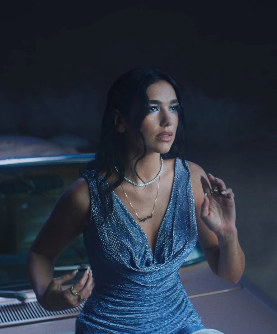 Dua Lipa in a shimmering blue gown with layered jewelry and dramatic makeup HD phone wallpaper