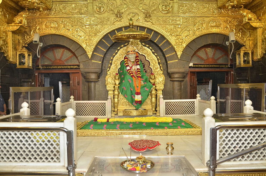 Sai Baba of Shirdi seated in ornate golden shrine with green robe and flower garlands HD wallpaper