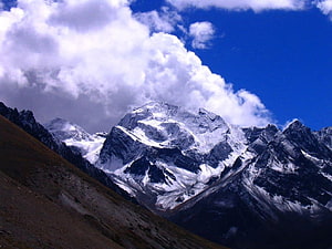 Snow-Capped Adi Kailash Peak Rising Above Rugged Himalayan Terrain Under a Dramatic Blue Sky HD wallpaper