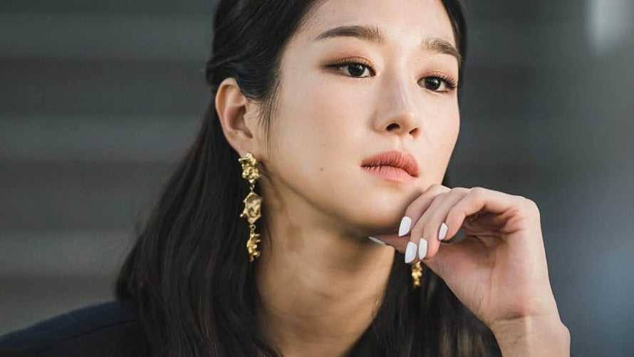 Seo Ye-ji in a contemplative close-up portrait with elegant gold earrings and dark hair HD wallpaper