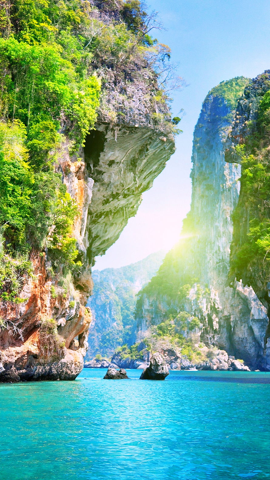 Towering limestone cliffs and turquoise sea in a tropical coastal landscape HD phone wallpaper